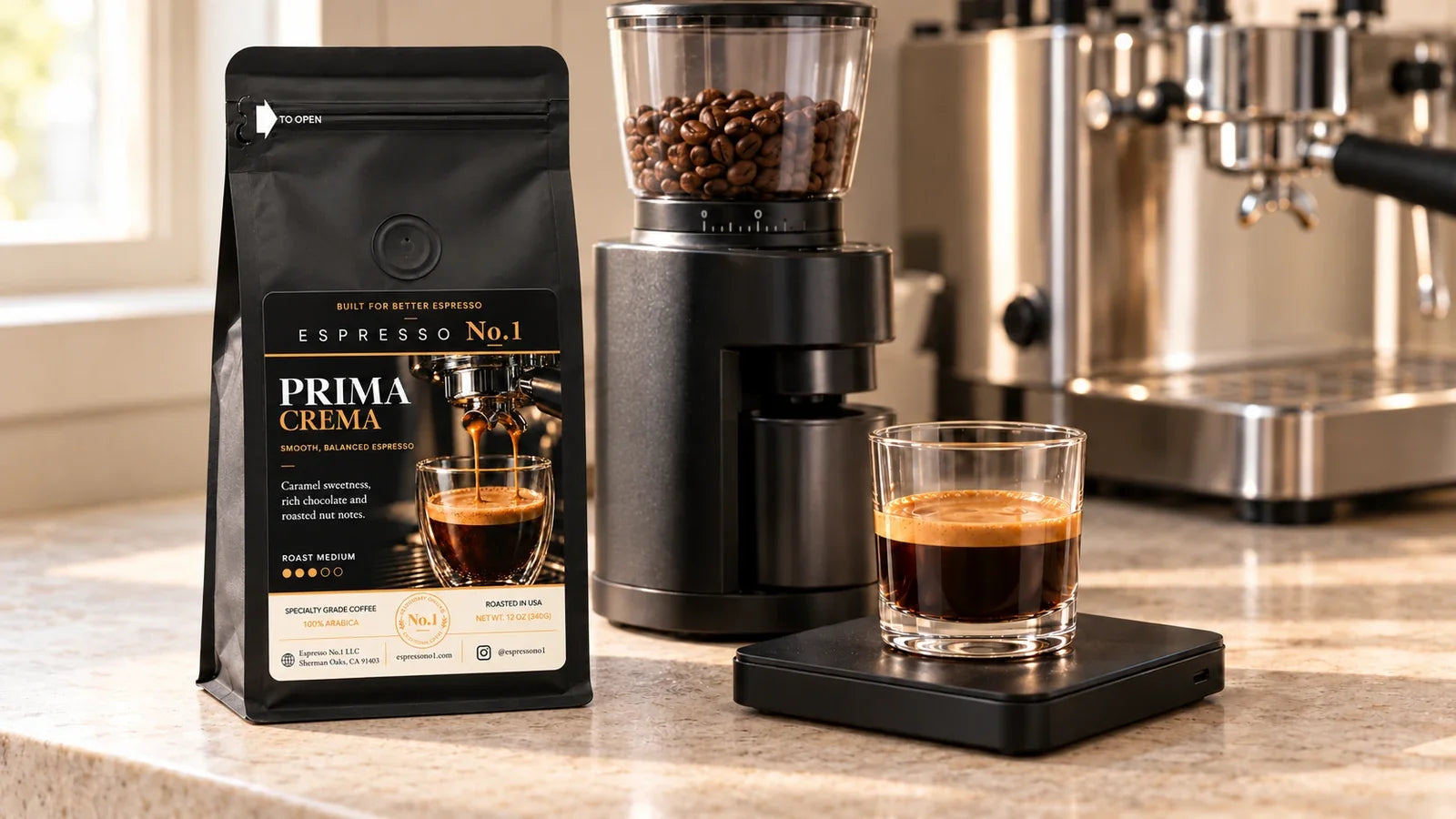 A Prima Crema coffee bag beside a burr grinder and espresso in a short clear glass on a black scale.